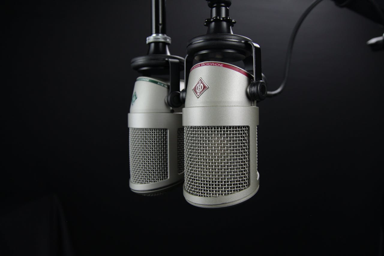 about-01 Close-up of two professional microphones in a recording studio, ideal for podcasts and music production.